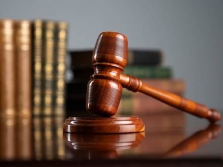A wooden gavel resting on a round block