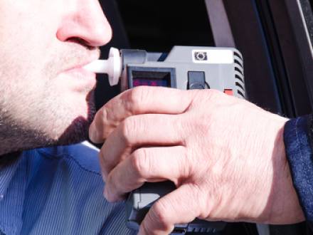 A person blowing into a breathalyzer device