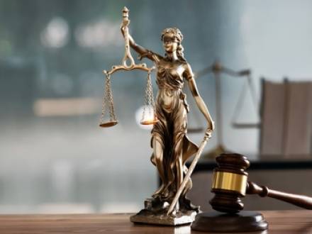 A statue of Lady Justice stands on a desk