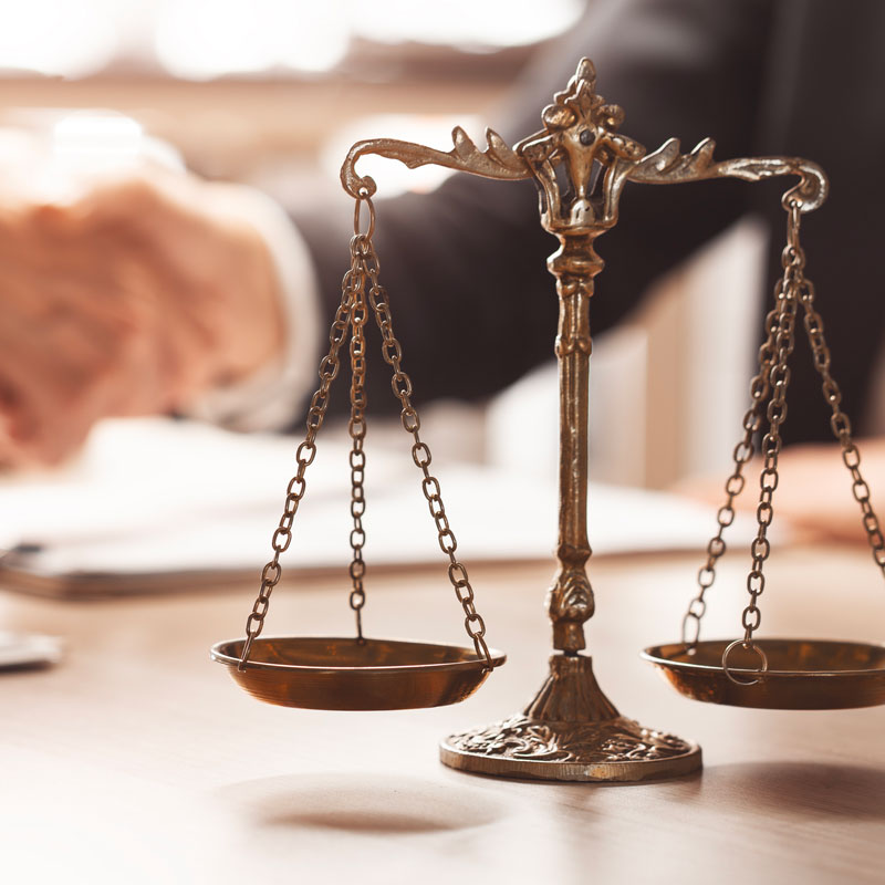 lawyers shaking hands and a justice scale