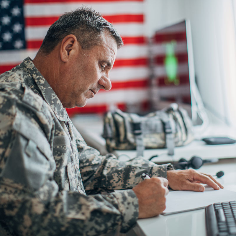 military person signing papers