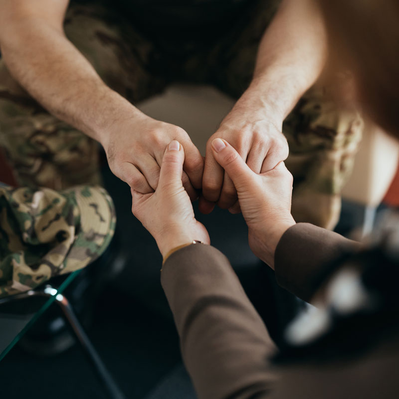 military person and therapist holding hands